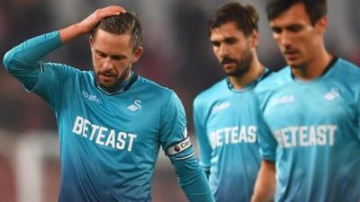 Swansea City players react after defeat to Stoke City