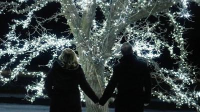 Andy and his wife in front of a tree