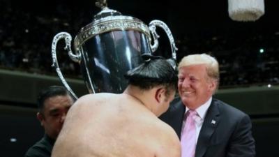 US President Donald Trump awards the a trophy at the Summer Grand Sumo Tournament in Tokyo