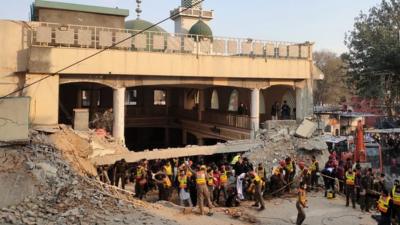 Rescue workers at the scene of a blast at a Mosque, in Peshawar, Pakistan,