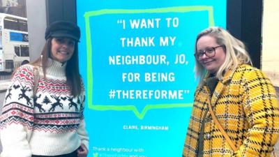 Jo Stretch and Claire Johnson next to the billboard