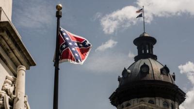 The Confederate battle flag flies on its last full day at the South Carolina state house