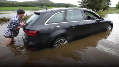 Farmer pushing car from flood water in North Yorkshire