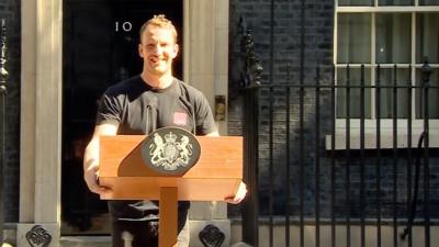 Sound man stands in front of the podium he has set up for Theresa May's speech