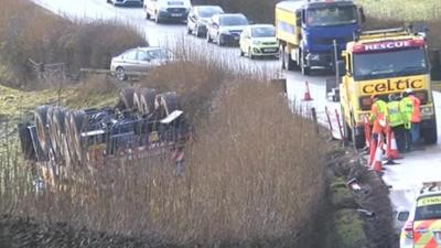 A clean-up operation begins after a 96-tonne crane topples into a Powys field and leaks fuel.