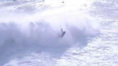 Surfer Alex Botelho being thrown by huge wave