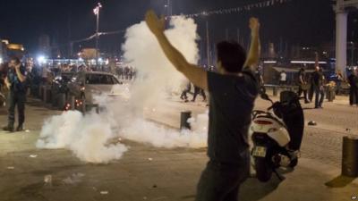 Man walking in front of teargas cloud used by police following scuffles in Marseille on 10 June