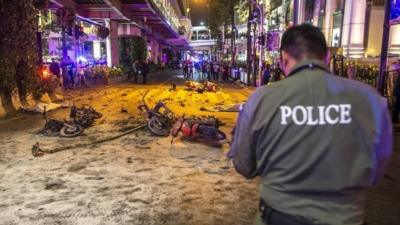 Police officers inspect the scene of an explosion near Erawan Shrine, central Bangkok