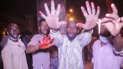 Sudan protesters hold up hands covered in blood