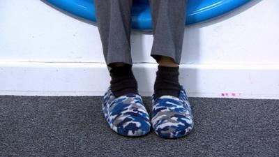 A child wears slippers to school