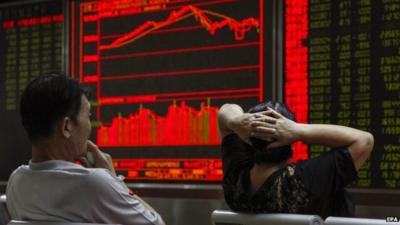 Investors monitor stock data on an electronic board at a securities brokerage house in Beijing,