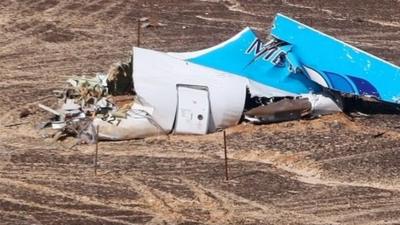 A handout picture from the Russian Emergency Ministry shows Russian Emergency Situations Minister Vladimir Puchkov (4-L) and unidentified officials near a piece of wreckage of Russian MetroJet Airbus A321 at the site of the crash in Sinai