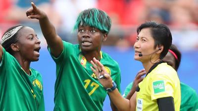 Cameroon players remonstrate with the referee