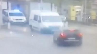 Grainy image of car driving at police van