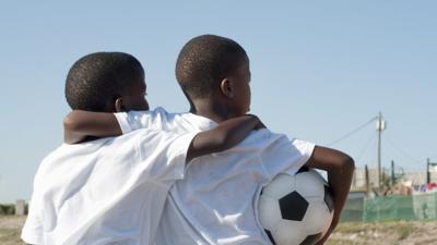 Two boys holding a football