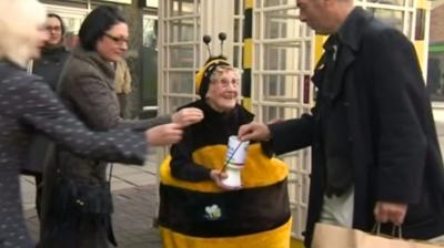 Woman collecting money for charity dressed in a bee costume