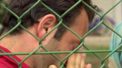 Tarik, Syrian migrant, wiping tears from his eyes