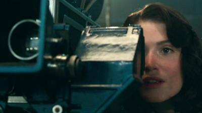 Actress Gemma Arterton looks into a film camera in a scene from Their Finest