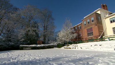 A blanket of snow covers a school playing field