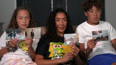 Kirsty Mattan and her children holding photos of her father