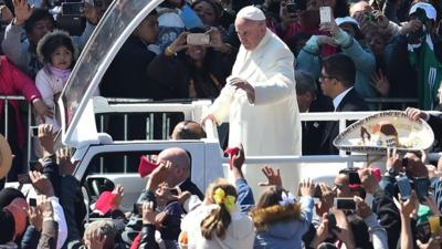 Pope Francis waves from the popemobile on his way to the cathedral, in Mexico City.