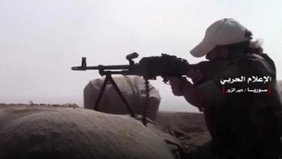 A fighter armed with a machine gun aims at an unseen target