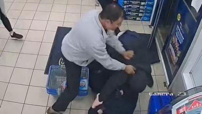 A man is seen on CCTV walking towards a door with a crate of beer before being tackled.