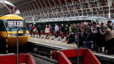 Railway enthusiasts photographing a train