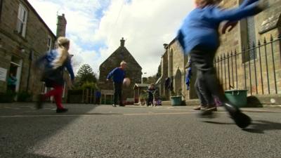 Primary school children playing football