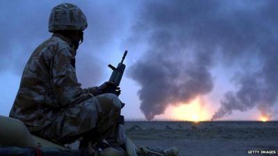 File photo from March 2003 showing a British soldier watching burning oil wells in Iraq