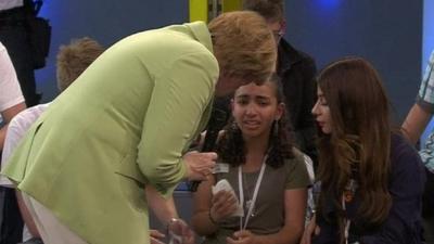 Angela Merkel comforting crying girl