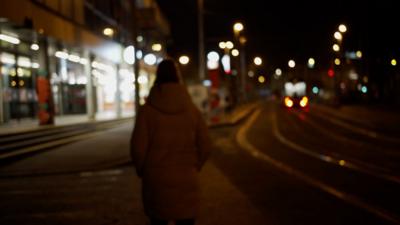 lone woman walking by tram tracks