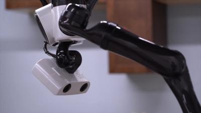 A robot head and robotic arm appear from the ceiling
