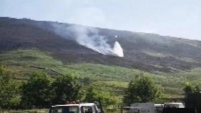 Helicopter drops water on fire