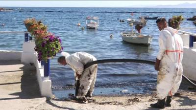 Workers try to clean the oil spill