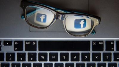 A keyboard, a pair of glasses and the Facebook logo