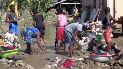 People collecting their belongings from the water