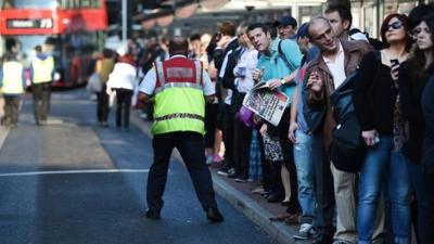 Commuters try to board buses at Victoria Station in London