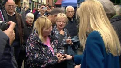 Woman speaking to Theresa May and Nicola Blackwood