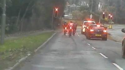 Cyclists about to go through red llight in Esher