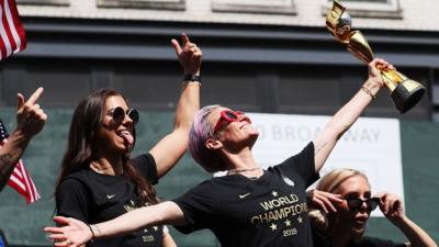 Alex Morgan and Megan Rapinoe celebrate at a parade for the World Cup winning team