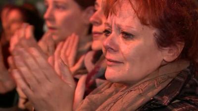 A tearful woman claps outside the Bataclan theatre in Paris