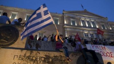 A woman waves a Greek flag during an anti-austerity pro-government rally