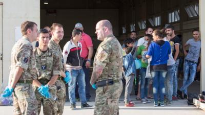 Syrian migrants are temporarily housed at a warehouse after coming ashore at RAF base Akrotiri in Cyprus.