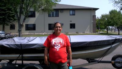 Lissa Yellowbird-Chase in front of her boat