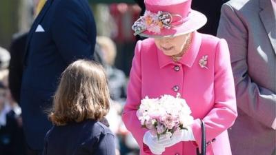 Girl giving Queen flowers