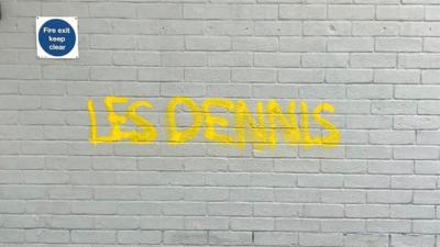 Les Dennis' name graffitied on a wall