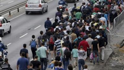 Migrants walk down a street from Keleti train station in Budapest, Hungary, September 5, 2015