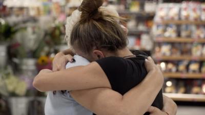 People hug at arrivals in Luton Airport