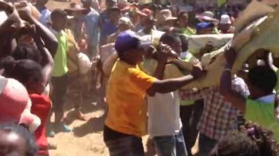 People carrying a shrouded corpse and dancing in Madagascar